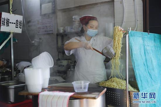 4月22日，武漢市糧道街的家陽“趙師傅”天天紅油熱干面店廚師在制作熱干面。新華社記者 沈伯韓 攝