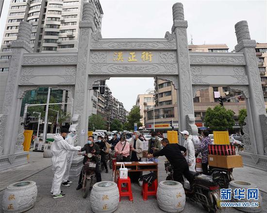  4月16日，進(jìn)出武漢漢正街步行街的人員在掃描健康碼。新華社記者 王毓國 攝